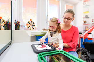 School aged girls and teacher using time timer app in the classroom 