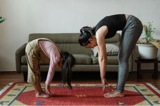 Mom and daughter stretching doing yoga