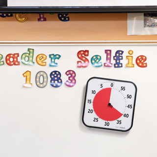 The Time Timer Original 12" has a magnetic back and is shown on a classroom whiteboard. 